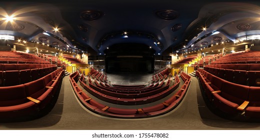 360 Degree spherical panorama sphere photo of the inside of an empty typical British theatre showing rows of empty  red chairs and a large open stage area below.