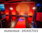 360 spinner photo booth setup with a red carpet and lighting in a venue with red ambient lighting.