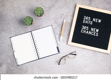 365 new days, 365 new chances. Letter board with motivational quote with notepad , pen, eye glasses and succulent. New year’s resolutions mockup. Flatlay, top view