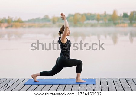 Similar – Active slim young woman doing yoga by the lake