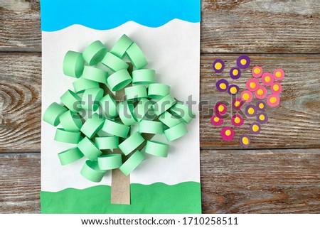 3D applique of colored paper, volume, spring tree with flowers, on a wooden background, handmade.