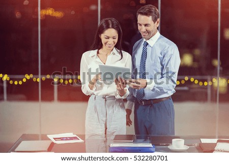 3D Businessman discussing with colleague over digital tablet in office