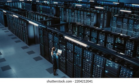 3D Computer Graphics: Data Center Female Chief Technology Officer Using Laptop Standing In Warehouse, Activates Servers, Information Digitalization Starts. SAAS, Cloud Computing, Online Service - Shutterstock ID 2204212041