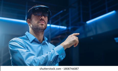 In 3D Content Creating Laboratory Engineer Wearing Professional Virtual Reality Headset Works and Gestures in Augmented Reality. Stylish Low Angle Portrait Shot - Powered by Shutterstock