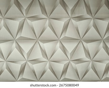 3D geometric pattern of grey triangles on decorative wall, suitable for modern background, architecture or interior design.