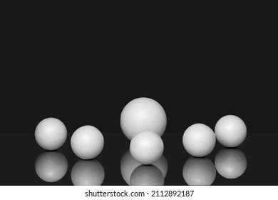3d geometric shapes on black isolated background with reflection. White three-dimensional spheres, of different sizes, scattered in chaotic manner.