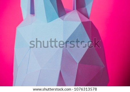 3D paper unicorn on pink background left side, horizontal. Origami toy. Origami pegasus