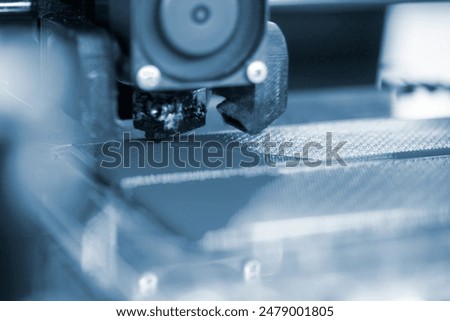 3D printer close up. A working 3D printer in process of printing object from molten plastic. 3D printer creating model by flowing liquid plastic from an extruder of printer. 3D printing technology
