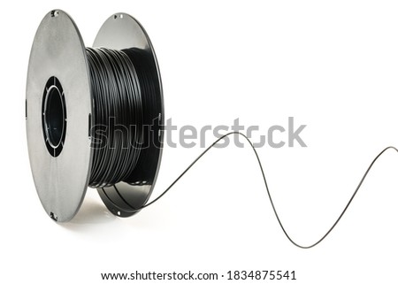 3D Printer Plastic Filament. Spool of black thermoplastic wire for 3D printing close up isolated on white background