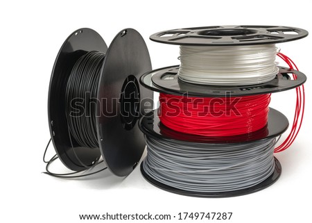 3D Printer Plastic Filament. Spools of black, red, grey, white thermoplastic wires  for 3d printing close up isolated on white background