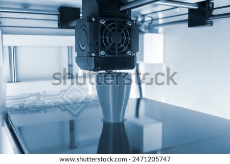 3D printer printing a model. Equipment of a 3D printer during the process of printing a model from molten plastic