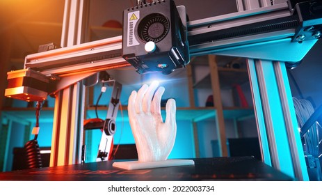 3d Printer Prints A Hand. 3d Printer At Work, Advertising Photo Blue And Orange Backlight. High Quality Photo