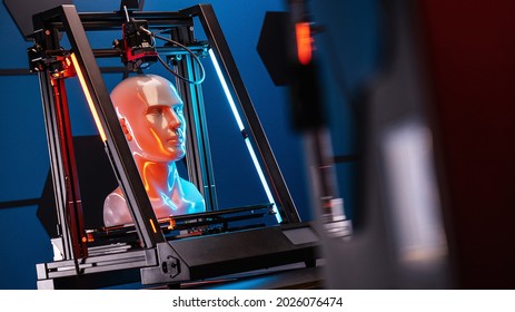3D printer at work. 3d printer prints head, advertising photo blue and orange light. High quality photo