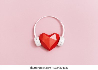 3d red paper heart in white headphones. Concept for music festivals, radio stations, music lovers.  Live with music. Minimal style. 