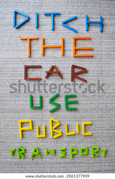 3D text in colour wooden bricks on wool carpet,\
which reads Ditch The Car Use Public Transport. Message for\
sustainability, climate change mitigation, climate action, carbon\
footprint reduction, CO2.