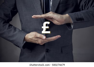 3D UK Pound Sterling Currency Sign In Between Two Hands Of Businessman.