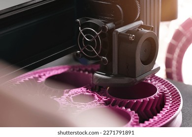 3D-printing of a planetary gear part from pink plastic filament in inspiring surrounding. selective focus. Visible infill structure and layers. View on print head. Modern production concept