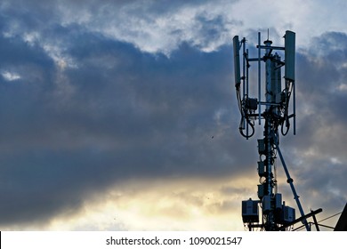 3G, 4G and 5G cellular. Macro Base Station or Base Transceiver Station. Telecommunication tower. Wireless Communication Antenna Transmitter agaisnt sunset with dark clouds.