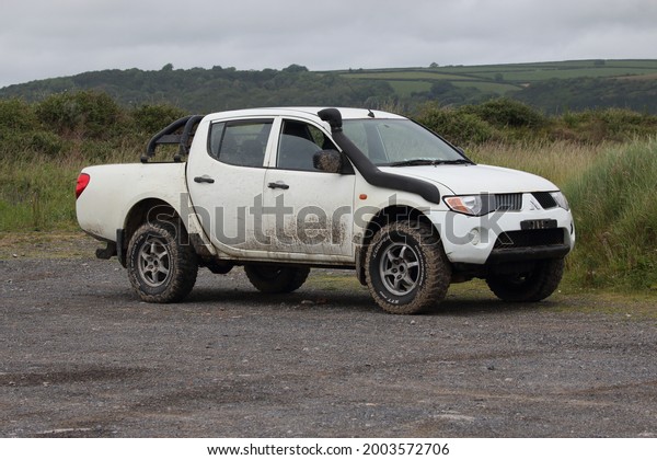 3rd July 2021- A\
rough looking Mitsubishi L200 4Life Di-D, double cab pick-up truck,\
in a public parking area at the Ginst Point near Laugharne,\
Carmarthenshire, Wales, UK.