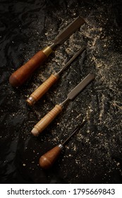 4 Chisels On Black Background With Saw Dust, Portrait Orientation