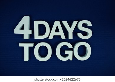 4 Days to go alphabet letters top view on navy blue background