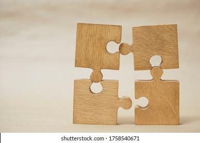 4 Four brown pieces of puzzle stand on wooden table isolated on yellow craft paper background. empty copy space for inscription or objects. idea, sign, symbol, concept of connecting