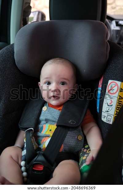4 month\
old Caucasian baby sitting in baby carrier safety car seat. child\
safety transport. family trips.\
holidays
