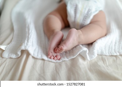 4 Months Old Baby Wearing Diapers Lying On The Bed At Home