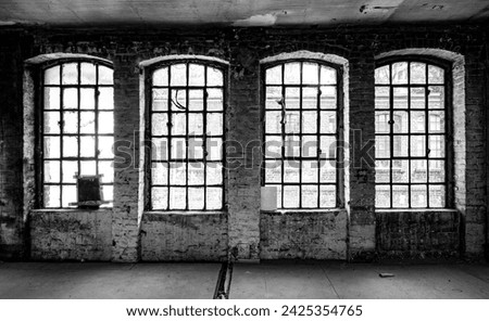 4 Old factory windows in ruined historic factory in Germany. Typical metal window frames with some broken, very filthy or mat panes. Lost place atmosphere, black and white with high contrast.