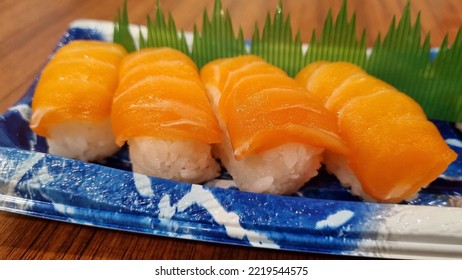 4 Salmon Sushi On Blue Plastic Plate