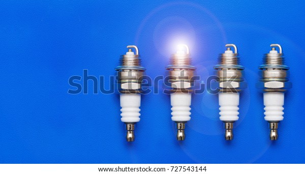 4 spark plugs on a blue background. Set of four\
spark plugs.
