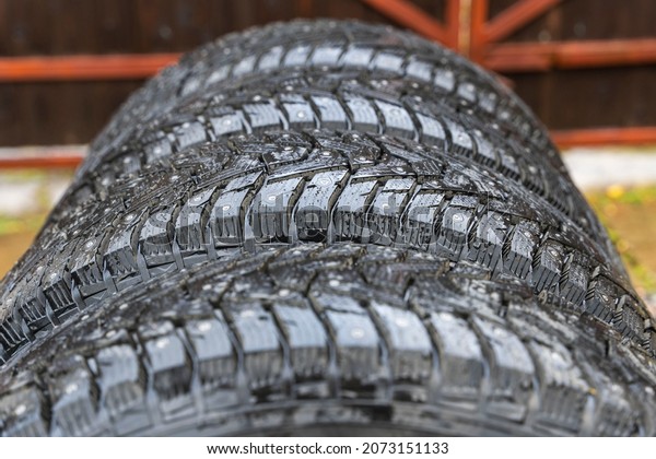 4 winter tires with spikes\
close-up, safety during winter driving, winter studded\
tires.