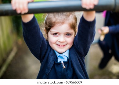 4 year old confident primary schoolgirl in school uniform looks forward to starting school