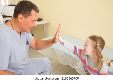 4 Year Old Patient Joyfully High Fives To The Male Doctor