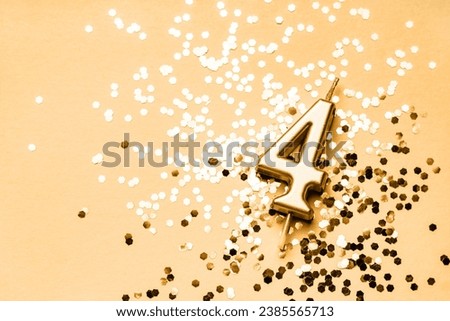 4 years celebration festive background made with golden candle in the form of number Four lying on sparkles. Universal holiday banner with copy space.