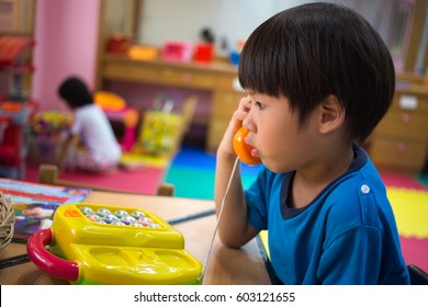 4 Years Old Asian Boy Playing Pick Up Toy Phone In Kid Room