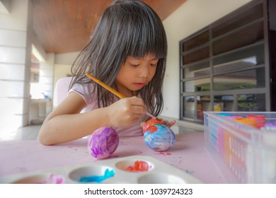 
4 Years Old Asian Little Cute Girl Painting On Easter Eggs. Painting Is Play Therapy For ADHD Kids (Attention Deficit Hyperactivity Disorder),can Be Used To Address Emotional Problems.
