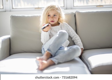 A 4 Years Old Child Watching Tv Laying Down On The Sofa At Home Alone