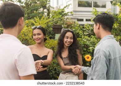 4 young people meet each other during a blind double date. Introducing oneself with a handshake. First time meeting after connecting via a dating app. - Shutterstock ID 2232138543