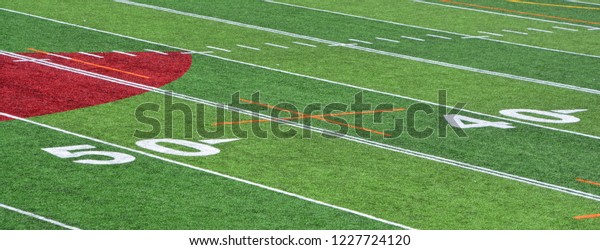 The 40 and 50-yard-line of an american football\
field with artificial turf