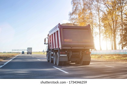 A 40 ton truck carries construction sand on the highway. Concept of overload on the roads and rental of a dump truck for work, copy space - Shutterstock ID 1734346259