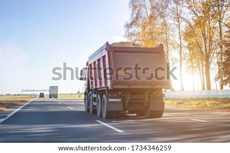 A 40 ton truck carries construction sand on the highway. Concept of overload on the roads and rental of a dump truck for work, copy space