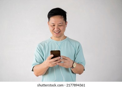 40 Year Old Man Happy With Headphones Listening To Music In Gray Background