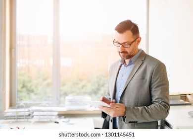 40 Years Old Handsome Businessman Working On Tablet Computer In Office. Man Working In Office