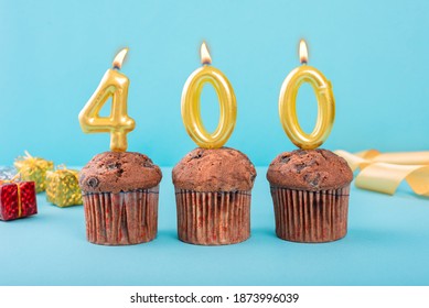 400 Number gold candle on a cupcake against a pastel blue background four hundred year celebration