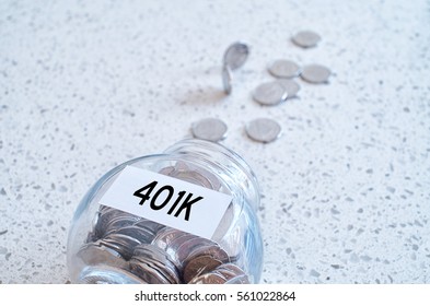 401k Retiring Plan Concept With A Glass Jar Full Of Coins On A Marble Counter Top