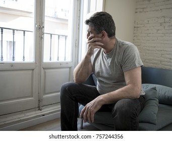 40s Or 50s Sad And Worried Man With Grey Hair Sitting At Home Couch Looking Depressed And Wasted In Sadness Face Expression In Depression And Life Problems Concept