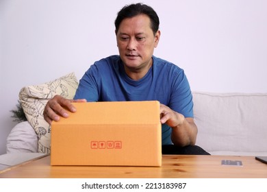 The 40s Adult Asian Man Opening The Mail Box In The Living Room.