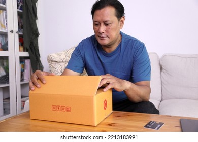 The 40s Adult Asian Man Opening The Mail Box In The Living Room.