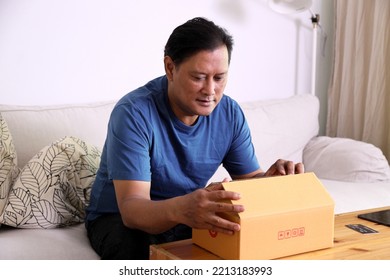 The 40s Adult Asian Man Opening The Mail Box In The Living Room.